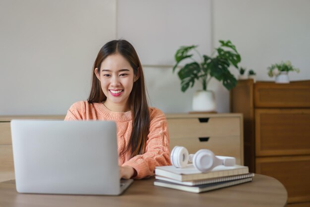 Donne sedute sul pavimento e che lavorano per digitare dati aziendali sul portatile nello stile di vita a casa