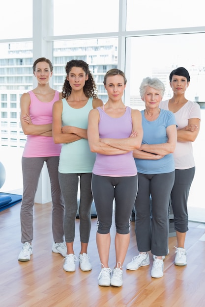Donne sicure con le braccia incrociate in classe di yoga