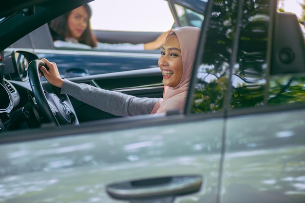 Donne sorridenti che guidano un'auto in città