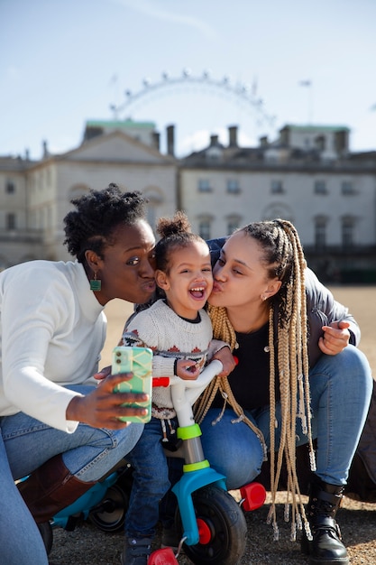 Donne sorridenti del colpo pieno che baciano il bambino