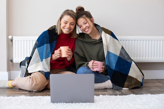 Donne sorridenti del colpo pieno con il computer portatile