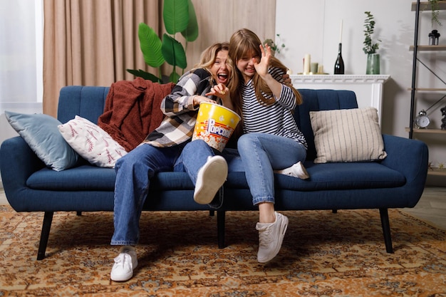 Donne spaventate che guardano film horror e mangiano popcorn a casa