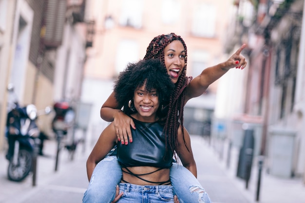 Donne spensierate saltando a vicenda durante le vacanze estive