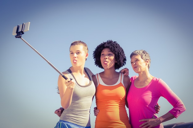 Donne sportive che posano e prendono autoscatti con il selfiestick