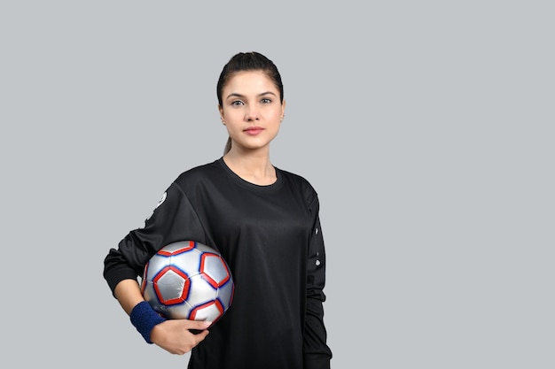 donne sportive in possesso di footballl e guardando il modello pakistano indiano davanti