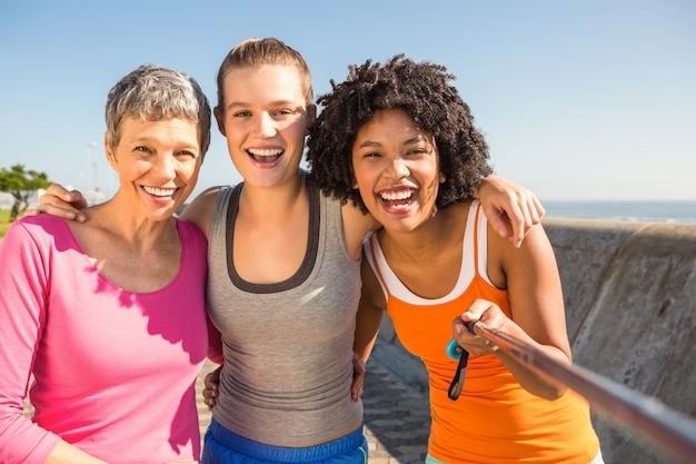 Donne sportive sorridenti che prendono i selfie con il selfiestick