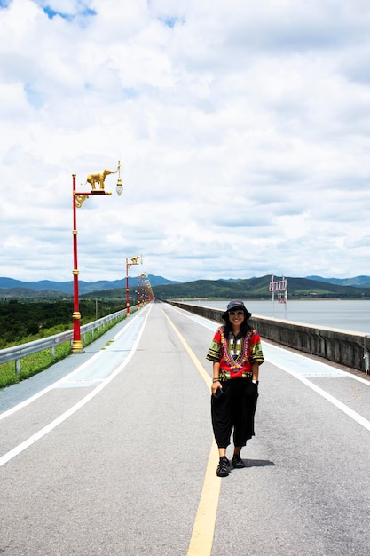 Donne tailandesi viaggiatori persone viaggio visita viaggio in posa ritratto per scattare foto con punto di vista sulla strada sulla cresta del serbatoio della diga di Krasiao a Dan Chang della città di Suphanburi a Suphan Buri Thailandia
