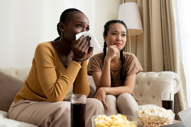 Donne tristi del colpo medio che guardano film