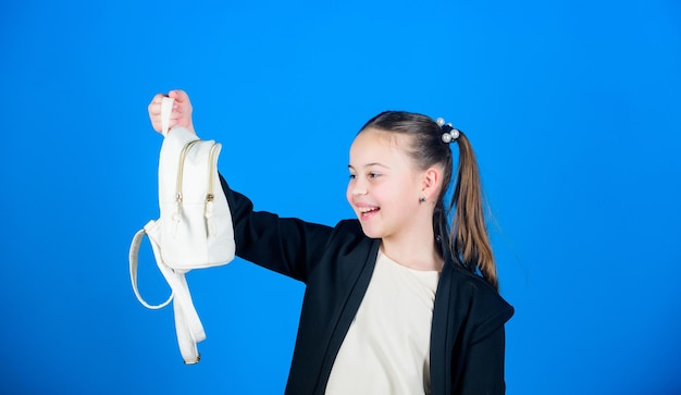 Dopo lo shopping Piccola ragazza che guarda la borsa della spesa Bambina che si diverte a fare shopping Adorabile ragazza con piccola borsa Cute bambino che tiene la borsa su sfondo blu Bambina che va a fare la spesa con la borsa da giorno