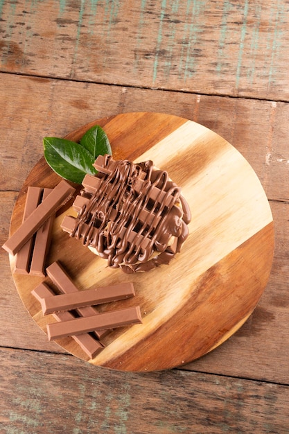 Doppia cialda con rivestimento di cioccolato su tavolette di cioccolato su vista dall'alto del tavolo in legno rustico