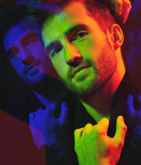 Doppia esposizione cyberpunk e ritratto di un uomo a colori isolato su uno sfondo scuro in studio Arte futuristica e modello in neon creativo ed illuminazione estetica con sovrapposizione su uno sfondo nero