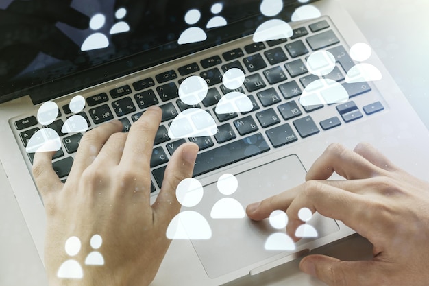 Doppia esposizione del concetto di icone dei social network con le mani che digitano sul laptop sullo sfondo Concetto di marketing e promozione