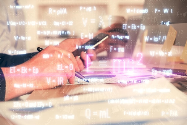 Doppia esposizione delle mani dell'uomo che tiene e usa un telefono e disegna formule concetto di istruzione