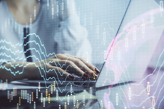 Doppia esposizione delle mani della donna che digitano sul computer e sul disegno dell'ologramma del grafico finanziario Concetto di analisi del mercato azionario