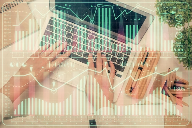 Doppia esposizione delle mani della donna che lavorano sul computer e sul disegno dell'ologramma del grafico forex Vista dall'alto Concetto di analisi finanziaria