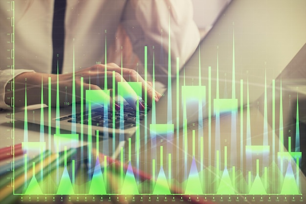 Doppia esposizione delle mani delle donne che digitano sul computer e disegno di ologramma di grafici finanziari concetto di analisi del mercato azionario