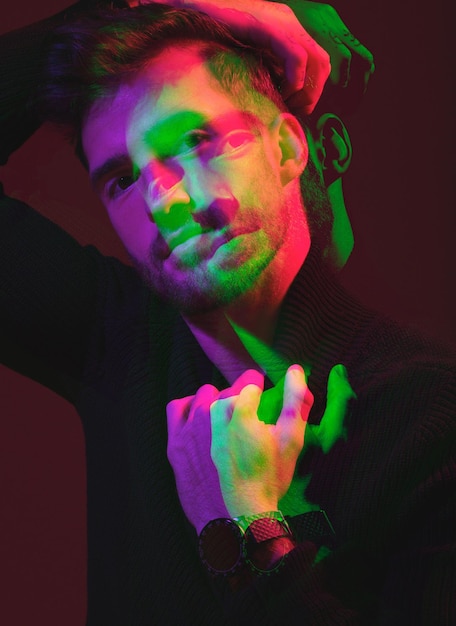 Doppia esposizione futuristica e ritratto di un uomo a colori isolato su uno sfondo scuro in studio arte 3d e modello in neon creativo ed illuminazione estetica con sovrapposizione su uno sfondo nero