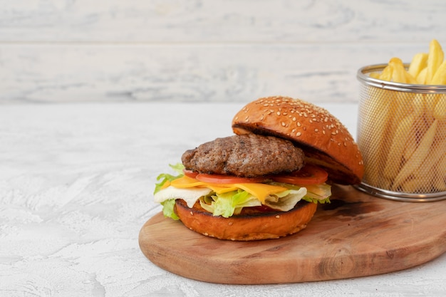 Doppio cheeseburger servito su tavola di legno contro bianco sfocato