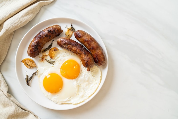 doppio uovo fritto fatto in casa con salsiccia di maiale fritta - per colazione