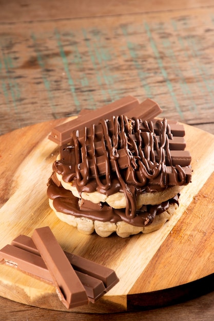 Doppio waffle con rivestimento di cioccolato su tavolette di cioccolato su tavola in legno rustico dall'alto