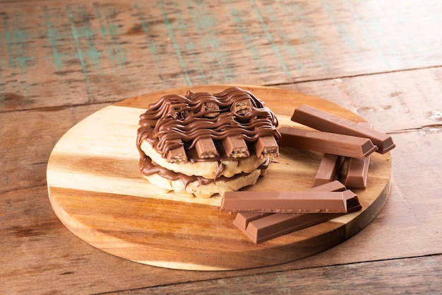 Doppio waffle con rivestimento di cioccolato su tavolette di cioccolato su tavolo in legno rustico in angolo ANTERIORE