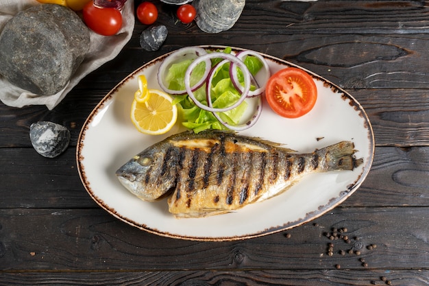 Dorada alla griglia con insalata, cipolle e pomodoro