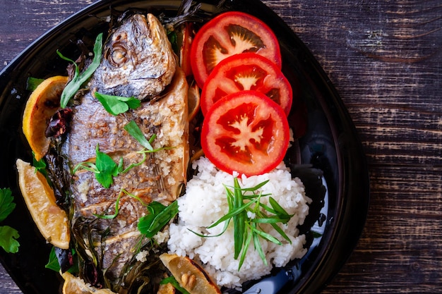 Dorada alla griglia con limone, prezzemolo, rosmarino e pomodori con contorno di riso bollito