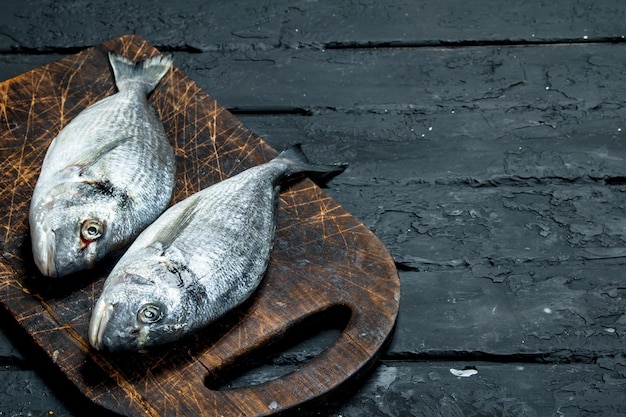 Dorado di pesce di mare crudo su un tagliere