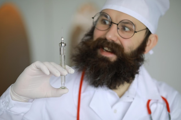 Dottor pazzo Uno scienziato pazzo della barba conduce esperimenti in un laboratorio scientifico Esegue ricerche utilizzando una siringa e uno stetoscopio