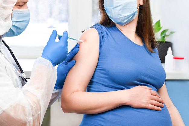 Dottore che dà l'iniezione del vaccino contro il coronavirus COVID-19 a una donna incinta Vaccinazione donna incinta