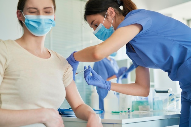 Dottore che dà la vaccinazione al paziente in ospedale