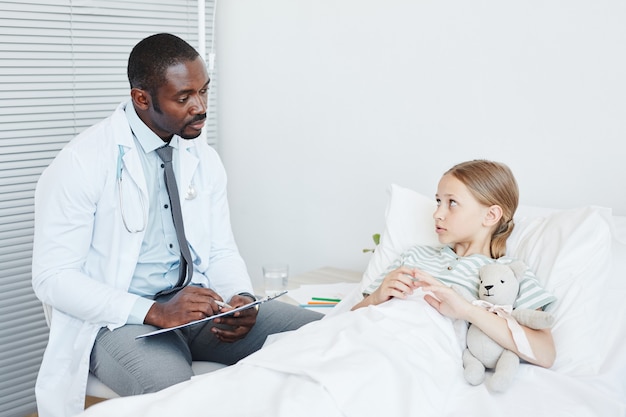 Dottore che parla con bambino in ospedale