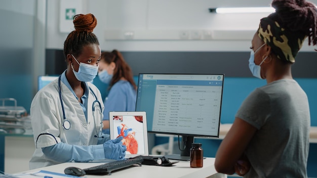 Dottore che punta al tablet con l'organo cardiaco sullo schermo