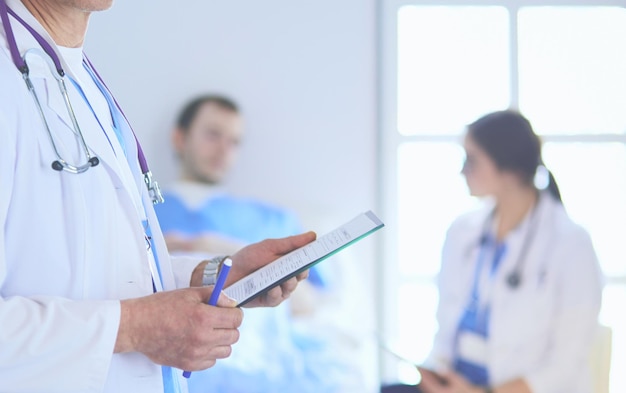 Dottore che tiene la cartella davanti a un paziente e a un medico