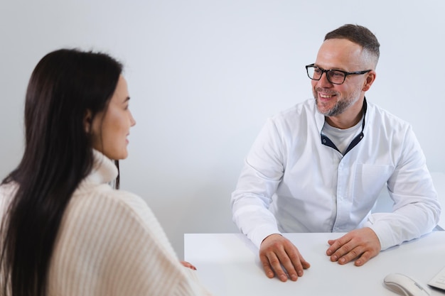 Dottore con gli occhiali che parla con il paziente durante l'appuntamento in clinica