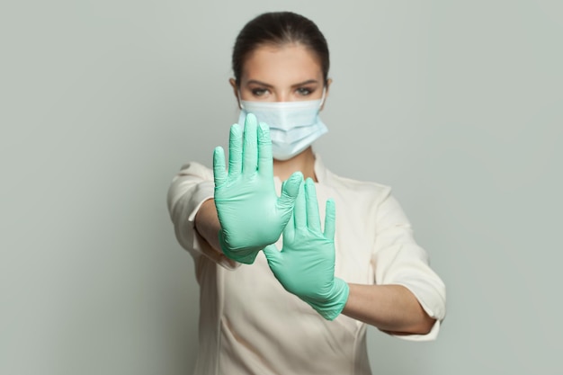 Dottore con le mani in gesto di stop su sfondo bianco Vaccinazione per la sicurezza medica e concetto di protezione contro il virus covid-19