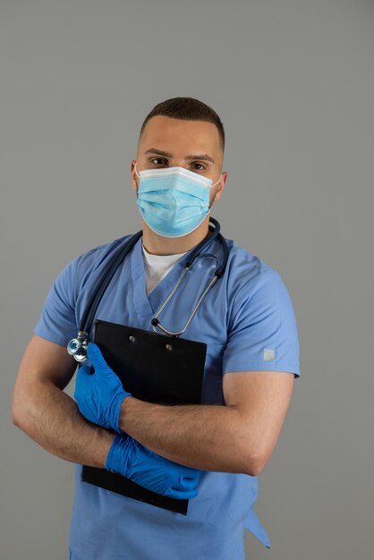 Dottore di sesso maschile in uniforme con clipboard isolato