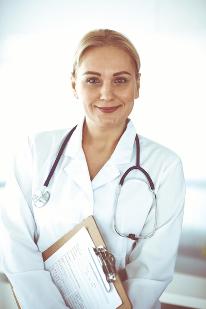 Dottore donna adulta in piedi dritta nell'ufficio dell'ospedale, ritratto. Servizio medico perfetto in clinica. Concepti di medicina e assistenza sanitaria.