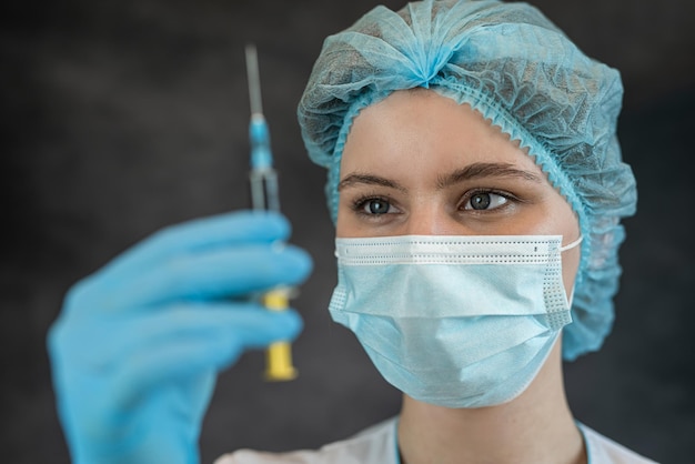 dottore in abiti protettivi con una siringa concetto di assistenza sanitaria medica