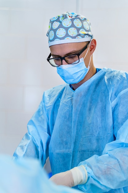 Dottore in sala operatoria con attrezzature chirurgiche. Medico che fornisce operazione. Background medico moderno