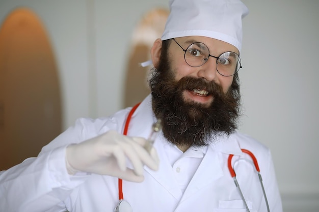 Dottore pazzo. Uno scienziato pazzo della barba conduce esperimenti in un laboratorio scientifico. Esegue la ricerca utilizzando una siringa e uno stetoscopio.