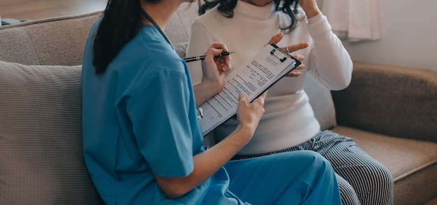 Dottoressa asiatica ha visitato la paziente per diagnosticare e controllare la salute a casa o in un ospedale privato La paziente spiega il problema di salute e i sintomi al medico Servizio premium di assistenza sanitaria a casa