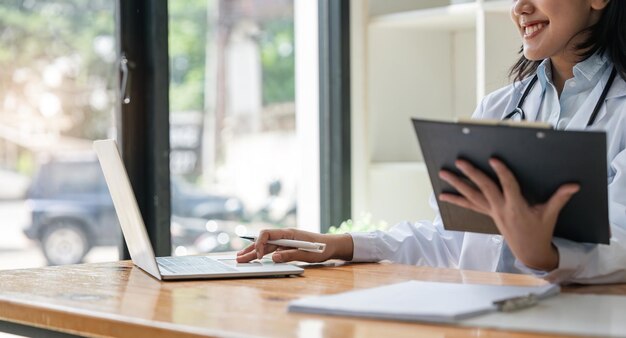 Dottoressa che lavora su un computer portatile in ufficio Assistenza sanitaria medica e concetto di servizio medico