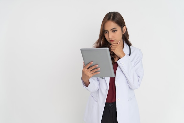 Dottoressa che pensa mentre guarda lo schermo del pad con la mano che tiene il mento