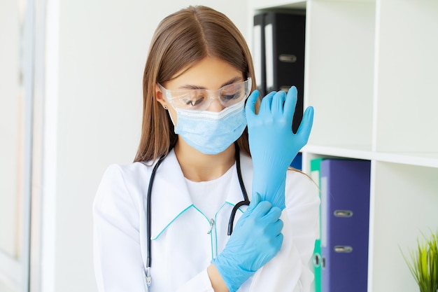 Dottoressa con maschera protettiva e guanti in ospedale