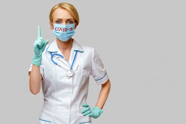Dottoressa con stetoscopio indossando maschera protettiva e guanti in gomma o lattice