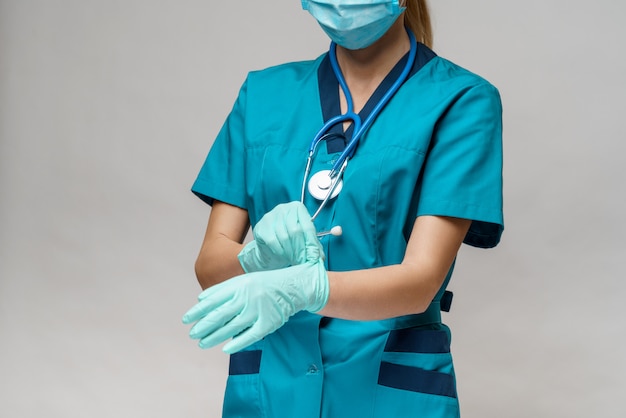 Dottoressa con stetoscopio indossando maschera protettiva e guanti in lattice