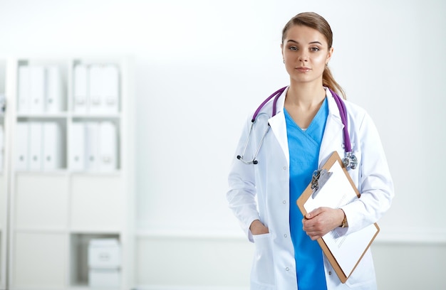 Dottoressa in piedi con cartella in ospedale