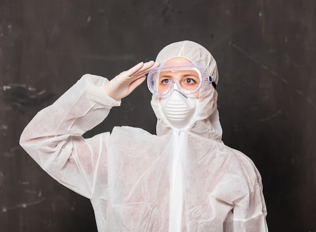 dottoressa in tuta protettiva e occhiali con maschera