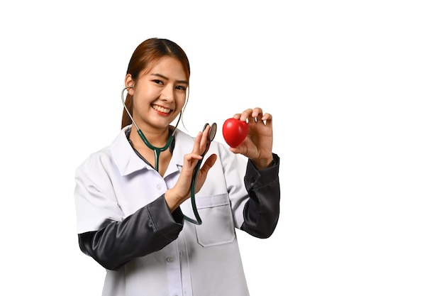 Dottoressa sorridente con uno stetoscopio e un cuore rosso isolato sullo sfondo bianco Concetto di medicina e assistenza sanitaria cardiologica